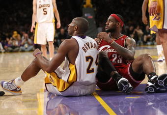 LOS ANGELES - JANUARY 27:  Kobe Bryant #24 of the Los Angeles Lakers and LeBron James #23 of the Cleveland Cavaliers sit on the floor after falling during play at Staples Center January 27, 2008 in Los Angeles, California. The Cavaliers won 98-95.  NOTE TO USER: User expressly acknowledges and agrees that, by downloading and/or using this Photograph, user is consenting to the terms and conditions of the Getty Images License Agreement. (Photo by Stephen Dunn/Getty Images)