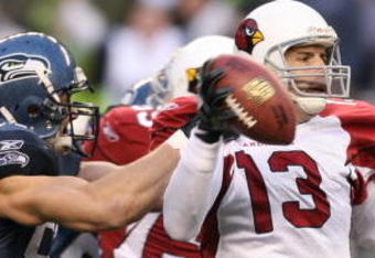 SEATTLE - DECEMBER 9:  Quarterback Kurt Warner #13 of the Arizona Cardinals is sacked by Patrick Kerney #97 of the Seattle Seahawks at Qwest Field December 9, 2007 in Seattle, Washington. The Seahawks defeated the Cardinals 42-21. (Photo by Otto Greule Jr/Getty Images)