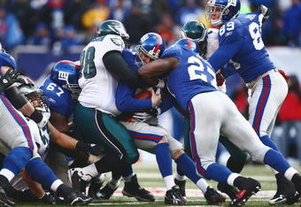 EAST RUTHERFORD, NJ -  JANUARY 11:  Eli Manning #10 of the New York Giants is tackled by Mike Patterson #98 of the Philadelphia Eagles during the NFC Divisional Playoff Game on January 11, 2009 at Giants Stadium in East Rutherford, New Jersey.  The Eagles defeated the Giants 23 -11. (Photo by Chris McGrath/Getty Images)