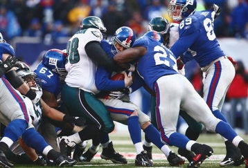 EAST RUTHERFORD, NJ -  JANUARY 11:  Eli Manning #10 of the New York Giants is tackled by Mike Patterson #98 of the Philadelphia Eagles during the NFC Divisional Playoff Game on January 11, 2009 at Giants Stadium in East Rutherford, New Jersey.  The Eagles defeated the Giants 23 -11. (Photo by Chris McGrath/Getty Images)