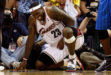 CLEVELAND - MAY 22:  LeBron James #23 of the Cleveland Cavaliers winces in pain on the sidelines during Game Two of the Eastern Conference Finals against the Orlando Magic during the 2009 Playoffs at Quicken Loans Arena on May 22, 2009 in Cleveland, Ohio. NOTE TO USER: User expressly acknowledges and agrees that, by downloading and or using this photograph, User is consenting to the terms and conditions of the Getty Images License Agreement  (Photo by Gregory Shamus/Getty Images)