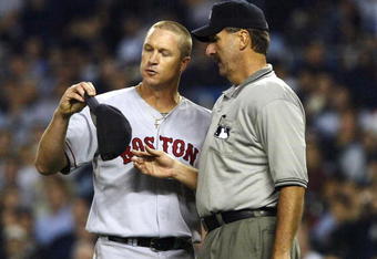BRONX, NY - OCTOBER 8:  Home plate umpire Tim McClelland inspects Boston Red Sox pitcher Mike Timlin's hat after being instructed to do so by manger Joe Torre of the New York Yankees during game 1 of the American League Championship Series on October 8, 2003 at Yankee Stadium in the Bronx, New York.  (Photo by Doug Pensinger/Getty Images)