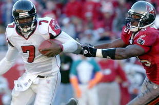 Atlanta Falcons quarterback Michael Vick scrambles from the Tampa Bay Buccaneers  pass rush December 20, 2003 at Raymond James Stadium, Tampa, Florida.  The Falcons defeated the Bucs 30 - 28.  (Photo by Al Messerschmidt/Getty Images)