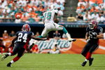 MIAMI - OCTOBER 26:  Wide receiver Ted Ginn Jr. #19 of the Miami Dolphins leaps up for a reception between cornerback Terrence McGee #24 and linebacker Kawika Mitchell #59 of the Buffalo Bills at Dolphin Stadium on October 26, 2008 in Miami, Florida. The Dolphins defeated the Bills 25-16.  (Photo by Doug Benc/Getty Images)