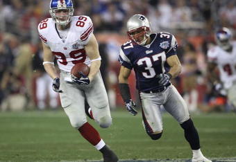 GLENDALE, AZ - FEBRUARY 03:  Kevin Boss #89 of the New York Giants runs for yards after the catch on a 45-yard reception against Rodney Harrison #37 of the New England Patriots in the fourth quarter of Super Bowl XLII on February 3, 2008 at the University of Phoenix Stadium in Glendale, Arizona.  (Photo by Andy Lyons/Getty Images)