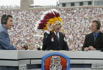 TALLAHASSEE, FL - OCTOBER 26:  ESPN College GameDay announcer Lee Corso dons an FSU headress as co-announcers (l to r) Chris Fowler and Kirk Herbstreit comment during the NCAA football game between Notre Dame and Florida State at Doak Campbell Stadium on October 26, 2002 in Tallahassee, Florida.  The Notre Dame Fighting Irish defeated the Florida State Seminoles 34-24.  (Photo by Craig Jones/Getty Images)