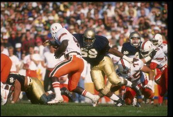 15 Oct 1988:  George Williams of the Notre Dame Fighting Irish (right) attempts to tackle a Miami Hurricanes player during a game at Notre Dame Stadium in South Bend, Indiana.  Notre Dame won the game, 31-30. Mandatory Credit: Jonathan Daniel  /Allsport