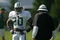 FARMINGDALE, NY - JULY 27:  JULY 27:  Running back Thomas Jones #20 of the New York Jets talks with coach Jimmy Raye during the first day of training camp on July 27, 2007 at Hofstra University in Farmingdale, New York.  (Photo by Mike Ehrmann/Getty Images)