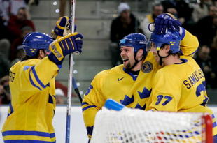 TURIN, ITALY - FEBRUARY 24:  Tomas Holmstrom #96 of Sweden celebrates with his teammates Mikael Samuelsson #37 and Henrik Zetterberg #40 after he scored the seventh goal in the third period during the semi final of the men's ice hockey match between Sweden and Czech Republic during Day 14 of the Turin 2006 Winter Olympic Games on February 24, 2006 at the Palasport Olimpico in Turin, Italy. Sweden won 7-3 to reach the final.  (Photo by Brian Bahr/Getty Images)