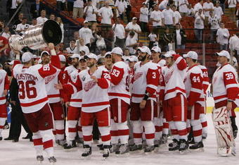 PITTSBURGH - JUNE 04: Tomas Holmstrom #96 of the Detroit Red Wings hands off to Brian Rafalski #28 as they celebrate with the Stanley Cup after defeating the Pittsburgh Penguins in game six of the 2008 NHL Stanley Cup Finals at Mellon Arena on June 4, 2008 in Pittsburgh. Pennsylvania. The Red Wings defeated the Penguins 3-2 to win the Stanley Cup Finals 4 games to 2. (Photo by Bruce Bennett/Getty Images)