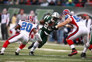 EAST RUTHERFORD, NJ - DECEMBER 14: Thomas Jones #20 of the New York Jets runs into Chris Kelsay #90 and Donte Whitner #20 of the Buffalo Bills during their game on December 14, 2008 at Giants Stadium in East Rutherford, New Jersey. (Photo by Al Bello/Getty Images)