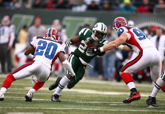 EAST RUTHERFORD, NJ - DECEMBER 14:  Thomas Jones #20 of the New York Jets runs into Chris Kelsay #90 and Donte Whitner #20 of the Buffalo Bills during their game on December 14, 2008 at Giants Stadium in East Rutherford, New Jersey.  (Photo by Al Bello/Getty Images)
