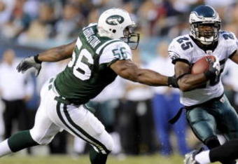 PHILADELPHIA - AUGUST 28: Lorenzo Booker #25 of the Philadelphia Eagles rushes as Vernon Gholston #56 of the New York Jets tries to make a tackle during a preseason game at Lincoln Financial Field on August 28, 2008 in Philadelphia, Pennsylvania. (Photo by Rob Tringali/Getty Images)