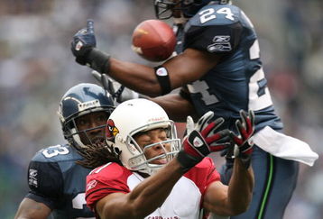 SEATTLE - DECEMBER 9:  Wide receiver Larry Fitzgerald #11 of the Arizona Cardinals fights to make a catch against Deon Grant #24 of the Seattle Seahawks at Qwest Field December 9, 2007 in Seattle, Washington. The ball fell incomplete. (Photo by Otto Greule Jr/Getty Images)