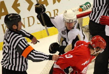 DETROIT - MAY 31:  Referee Marc Joannette tries to break up a fight between Evgeni Malkin #71 of the Pittsburgh Penguins fights and Henrik Zetterberg #40 of the Detroit Red Wings as their teams fight in the background towards the end of Game Two of the 2009 Stanley Cup Finals at Joe Louis Arena on May 31, 2009 in Detroit, Michigan.  (Photo by Claus Andersen/Getty Images)