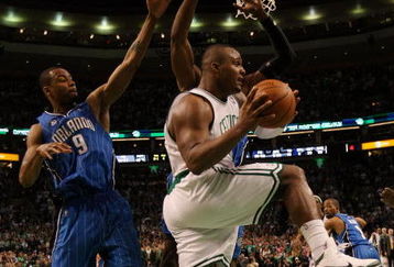 BOSTON - MAY 12:  Glen Davis #11 of the Boston Celtics passes the ball as Rashard Lewis #9 and Dwight Howard #12 of the Orlando Magic defend in Game Five of the Eastern Conference Semifinals during the 2009 NBA Playoffs at TD Banknorth Garden May 12, 2009 in Boston, Massachusetts. The Celtics defeated the Magic 92-88.  NOTE TO USER: User expressly acknowledges and agrees that, by downloading and or using this photograph, User is consenting to the terms and conditions of the Getty Images License Agreement.  (Photo by Elsa/Getty Images)