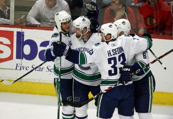 CHICAGO - MAY 11:  (L-R) Kevin Bieksa #3, Daniel Sedin #22, Henrik Sedin #33 and Sami Salo #6 of the Vancouver Canucks celebrate after Daniel Sedin scored a goal in the third period against the Chicago Blackhawks during Game Six of the Western Conference Semifinal Round of the 2009 Stanley Cup Playoffs on May 11, 2009 at the United Center in Chicago, Illinois. The Blackhawks won 7-5.  (Photo by Jonathan Daniel/Getty Images)