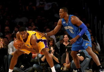 LOS ANGELES, CA - JANUARY 16: Andrew Bynum #17 of the Los Angeles Lakers holds the all away from Dwight Howard #12 of the Orlando Magicon January 16, 2009 at Staples Center in Los Angeles, California. The Magic won 109-103.   NOTE TO USER: User expressly acknowledges and agrees that, by downloading and/or using this Photograph, user is consenting to the terms and conditions of the Getty Images License Agreement.  (Photo by Stephen Dunn/Getty Images)