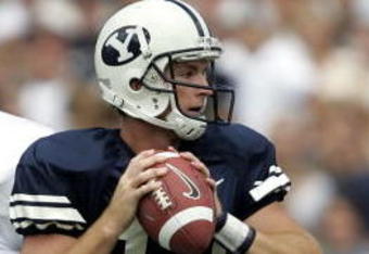 PROVO, UT - SEPTEMBER 3:  Quarterback John Beck #12 of the Brigham Young Cougars looks to pass the ball as defensive end Nick Larkin #57 of the Boston College Eagles moves in on September 3, 2005 at LaVell Edwards Stadium in Provo, Utah.  (Photo by George Frey/Getty Images)