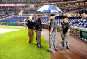 WASHINGTON - JUNE 03:  Assistant General Manager Mike Rizzo of the Washington Nationals talks with Jeff Kellogg and the umpire crew during a rain delay of the game between the San Francisco Giants and the Washington Nationals at Nationals Park on June 3, 2009 in Washington, DC.  (Photo by Greg Fiume/Getty Images)