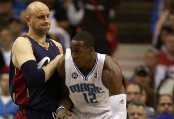 ORLANDO, FL - MAY 30: Dwight Howard #12 of the Orlando Magic handles the ball against Zydrunas Ilgauskas #11 of the Cleveland Cavaliers in Game Six of the Eastern Conference Finals during the 2009 Playoffs at Amway Arena on May 30, 2009 in Orlando, Florida. NOTE TO USER: User expressly acknowledges and agrees that, by downloading and or using this photograph, User is consenting to the terms and conditions of the Getty Images License Agreement  (Photo by Elsa/Getty Images)