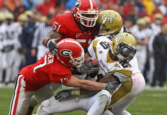 ATHENS, GA - NOVEMBER 29:  Defensive teammates Chad Gloer #17 and Akeem Dent #51 of the Georgia Bulldogs tackle running back Roddy Jones #20 of the Georgia Tech Yellow Jackets while Jones' teammate Marcus Wright #3 tries to block during the game at Sanford Stadium on November 29, 2008 in Athens, Georgia.  The Yellow Jackets defeated the Bulldogs 45-42.  (Photo by Mike Zarrilli/Getty Images)