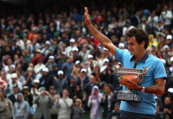 PARIS - JUNE 07:   Roger Federer of Switzerland salutes the fans as he holds the trophy following victory during the Men's Singles Final match against Robin Soderling of Sweden on day fifteen of the French Open at Roland Garros on June 7, 2009 in Paris, France.  (Photo by Ryan Pierse/Getty Images)