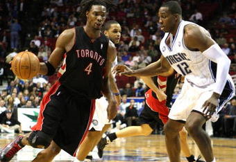 ORLANDO, FL - NOVEMBER 18: Chris Bosh #4 of the Toronto Raptors drives against Dwight Howard #12 of the Orlando Magic during the game on November 18, 2008 at Amway Arena in Orlando, Florida.  NOTE TO USER: User expressly acknowledges and agrees that, by downloading and/or using this Photograph, user is consenting to the terms and conditions of the Getty Images License Agreement.  (Photo by Sam Greenwood/Getty Images)