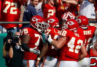 KANSAS CITY, MO - SEPTEMBER 28:  Fans cheer as teammates congratulate Larry Johnson #27 of the Kansas City Chiefs after Johnson rushed for a touchdown during the fourth quarter of the game against the Denver Broncos on September 28, 2008 at Arrowhead Stadium in Kansas City, Missouri.  (Photo by Jamie Squire/Getty Images)