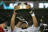 PHILADELPHIA - JANUARY 23: Quarterback Donovan McNabb #5 of the Philadelphia Eagles celebrates with the George Halas NFC Championship trophy after defeating the Atlanta Falcons 27-10 in the NFC Championship game at Lincoln Financial Field on January 23, 2005 in Philadelphia, Pennsylvannia. (Photo by Brian Bahr/Getty Images)