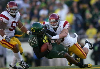 EUGENE, OR - OCTOBER 27:  Quarterback Dennis Dixon #10 of the Oregon Ducks is hit by Brian Crushing #10 of the Southern California Trojans at Autzen Stadium October 27, 2007 in Eugene, Oregon.  (Photo by Jonathan Ferrey/Getty Images)