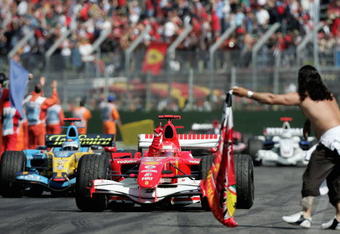 IMOLA, ITALY - APRIL 23:  Michael Schumacher of Germany and Ferrari celebrates winning the San Marino Formula One Grand Prix as he enters the pitlane in front of Fernando Alonso of Spain and Renault at the San Marino Circuit on April 23, 2006, in Imola, Italy.  (Photo by Paul Gilham/Getty Images)