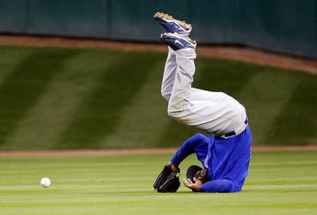 HOUSTON - APRIL 06:  Milton Bradley #21 of the Chicago Cubs flips over after missing a fly ball against the Houston Astros on Opening Day on April 6, 2009 at Minute Maid Park in Houston, Texas.  The Cubs defeated the Astros 4-2.  (Photo by Chris Graythen/Getty Images)