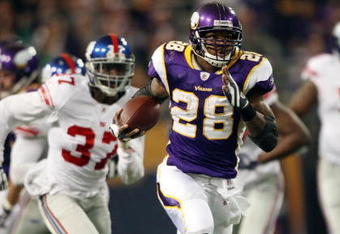 MINNEAPOLIS - DECEMBER 28:   Adrian Peterson #28 of the Minnesota Vikings runs the ball in for a touchdown as James Butler of the New York Giants defends on December 28, 2008 at the Hubert H. Humphrey Metrodome in Minneapolis, Minnesota. The Vikings defeated the Giants 20-19. (Photo by Elsa/Getty Images)