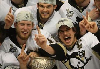 DETROIT - JUNE 12: (L-R) Jordan Staal #11, Chris Kunitz #14 and Sidney Crosby #87 of the Pittsburgh Penguins celebrate with the Stanley Cup after defeating the Detroit Red Wings by a score of 2-1 to win Game Seven and the 2009 NHL Stanley Cup Finals at Joe Louis Arena on June 12, 2009 in Detroit, Michigan. (Photo by Bruce Bennett/Getty Images)