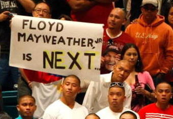 LAS VEGAS - MAY 01:  A sign for Floyd Mayweather Jr. is held as boxing fans wait for the official weigh-in for the junior welterweight title fight between Ricky Hatton of England and Manny Pacquiao of the Philippines at the MGM Grand Garden Arena May 1, 2009 in Las Vegas, Nevada. It was reported that on May 2 Mayweather will announce the end of his retirement to fight Juan Manuel Marquez.  (Photo by Ethan Miller/Getty Images)