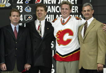 NASHVILLE, TN - JUNE 21:  (L to R) Mike Sands, Tod Button, first round (#9 overall) draft pick Dion Phaneuf, and Darryl Sutter of the Calgary Flames pose for a portrait on stage during the 2003 NHL Entry Draft at the Gaylord Entertainment Center on June 21, 2003 in Nashville, Tennessee. (Photo by Elsa/Getty Images/NHLI)