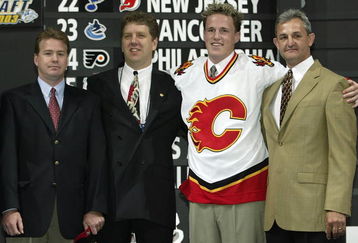 NASHVILLE, TN - JUNE 21:  (L to R) Mike Sands, Tod Button, first round (#9 overall) draft pick Dion Phaneuf, and Darryl Sutter of the Calgary Flames pose for a portrait on stage during the 2003 NHL Entry Draft at the Gaylord Entertainment Center on June 21, 2003 in Nashville, Tennessee. (Photo by Elsa/Getty Images/NHLI)