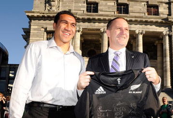 WELLINGTON, NEW ZEALAND - JUNE 15:  New Zealand Prime Minister John Key (R) receives a signed New Zealand All Blacks jersey from captain Mils Muliaina following an All Blacks flag raising ceremony at the New Zealand Parliament Building on June 15, 2009 in Wellington, New Zealand. The All Blacks are in Wellington to play France in the second test of their two match series, having lost the first 27-22.  (Photo by Ross Land/Getty Images)