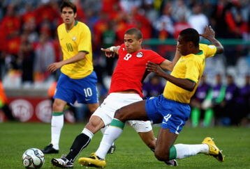 BLOEMFONTEIN, SOUTH AFRICA - JUNE 15: Mohamed  Zidan of Egypt battles is tackled by Juan of Brazil during the FIFA Confederations Cup match between Brazil and Egypt at The Free State Stadium on June 15, 2009 in Bloemfontein, South Africa.  (Photo by Laurence Griffiths/Getty Images)