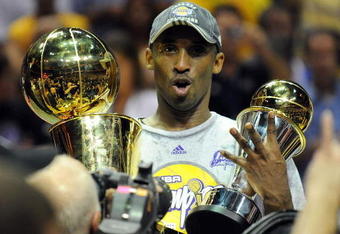 ORLANDO, FL - JUNE 14:  Kobe Bryant #24 of the Los Angeles Lakers holds up the Larry O'Brien trophy and the MVP trophy after the Lakers defeated the Orlando Magic 99-86 in Game Five of the 2009 NBA Finals on June 14, 2009 at Amway Arena in Orlando, Florida.  NOTE TO USER:  User expressly acknowledges and agrees that, by downloading and or using this photograph, User is consenting to the terms and conditions of the Getty Images License Agreement.  (Photo by Ronald Martinez/Getty Images)