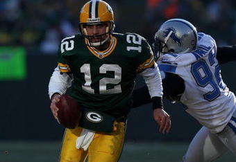 GREEN BAY, WI - DECEMBER 28: Aaron Rodgers #12 of the Green Bay Packers breaks away from Cliff Avril #92 of the Detroit Lions on December 28, 2008 at Lambeau Field in Green Bay, Wisconsin. The Packers defeated the Lions 31-21. (Photo by Jonathan Daniel/Getty Images)