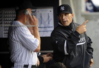 NEW YORK - JUNE 13:  Joe Girardi #27 confers with Dave Eiland #58 of the New York Yankees in the fifth inning against the New York Mets on June 13, 2009 at Yankee Stadium in the Bronx Borough of New York City.  (Photo by Jeff Zelevansky/Getty Images)