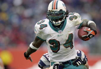 FOXBORO, MA - DECEMBER 29:  Ricky Williams #34 of the Miami Dolphins runs the ball during the game against the New England Patriots at Gillette Stadium on December 29, 2002 in Foxboro, Massachusetts. The Patriots defeated the Dolphins 27-24 in overtime. (Photo by Ezra Shaw/Getty Images)