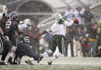 SEATTLE - DECEMBER 21:  Quarterback Brett Favre #4 of the New York Jets is grabbed by Darryl Tapp #55 of the Seattle Seahawks on December 21, 2008 at Qwest Field in Seattle, Washington. The Seahawks defeated the Jets 13-3. (Photo by Otto Greule Jr/Getty Images)