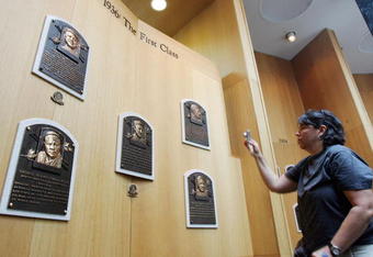 COOPERSTOWN, NY - JULY 26:  A baseball fan photographs plaques of the first five players inducted into the National Baseball Hall of Fame and Museum during the Baseball Hall of Fame weekend on July 26, 2008 in Cooperstown, New York.  (Photo by Jim McIsaac/Getty Images)