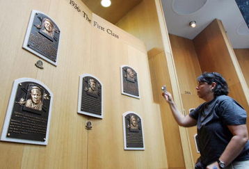 COOPERSTOWN, NY - JULY 26:  A baseball fan photographs plaques of the first five players inducted into the National Baseball Hall of Fame and Museum during the Baseball Hall of Fame weekend on July 26, 2008 in Cooperstown, New York.  (Photo by Jim McIsaac/Getty Images)