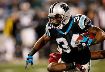 CHARLOTTE, NC - JANUARY 10:  DeAngelo Williams #34 of the Carolina Panthers runs against Gerald Hayes #54 of the Arizona Cardinals during the NFC Divisional Playoff Game on January 10, 2009 at Bank of America Stadium in Charlotte, North Carolina.  (Photo by Kevin C. Cox/Getty Images)