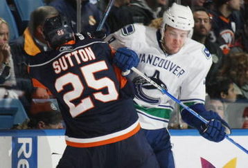 UNIONDALE, NY - NOVEMBER 17: Andy Sutton #25 of the New York Islanders hits Taylor Pyatt #9 of the Vancouver Canucks on November 17, 2008 at the Nassau Coliseum in Uniondale, New York. (Photo by Bruce Bennett/Getty Images)