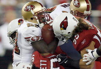 GLENDALE, AZ - NOVEMBER 10:  Frank Gore #21 of the San Francisco 49ers is stopped by Darnell Dockett #90 and Travis LaBoy #55 of the Arizona Cardinals during the third quarter at University of Phoenix Stadium on November, 10 2008 in Glendale, Arizona.  (Photo by Harry How/Getty Images)